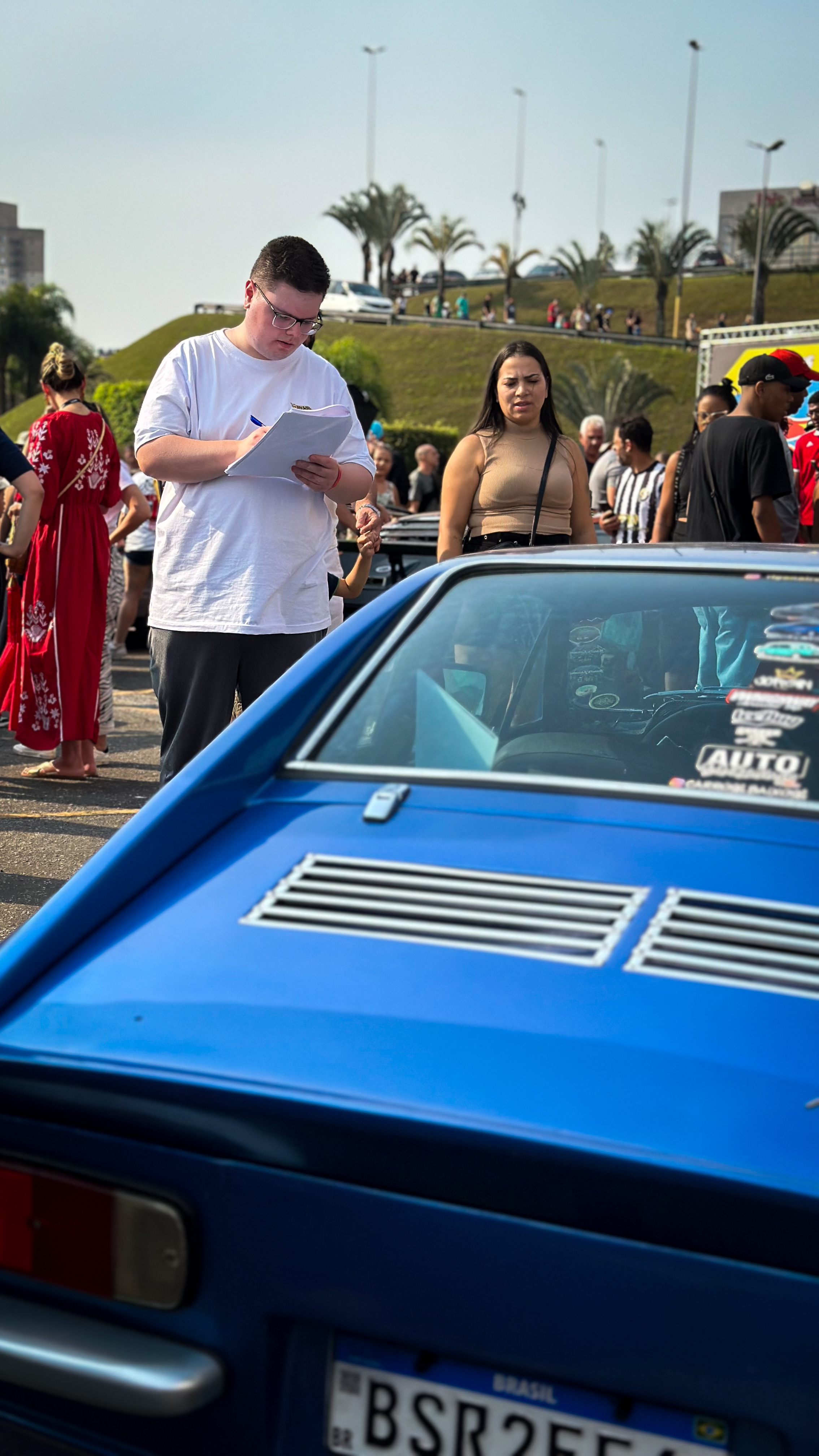 Beloto em evento automotivo com carro azul